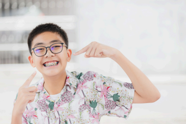 Kid Pointing at his smiles and braces
